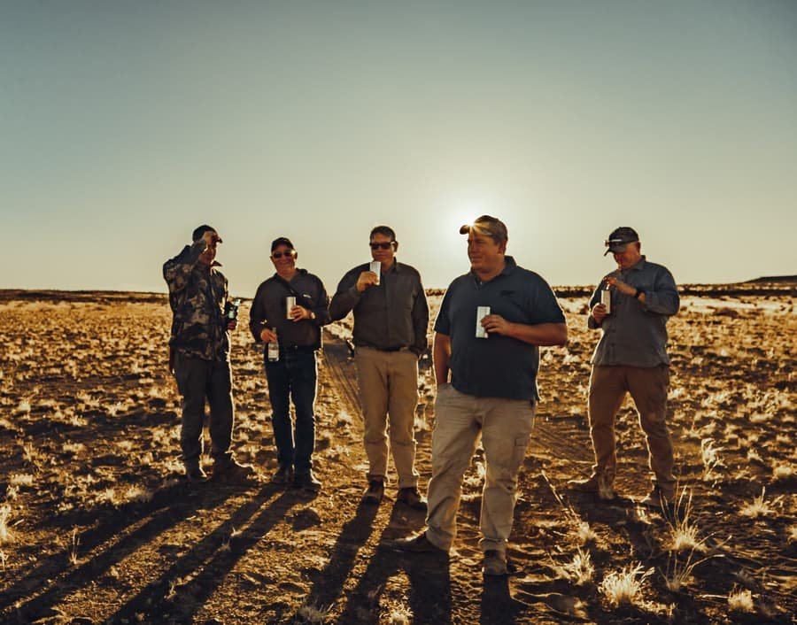 A hunting group raising a toast on the Karoo veld at sunset